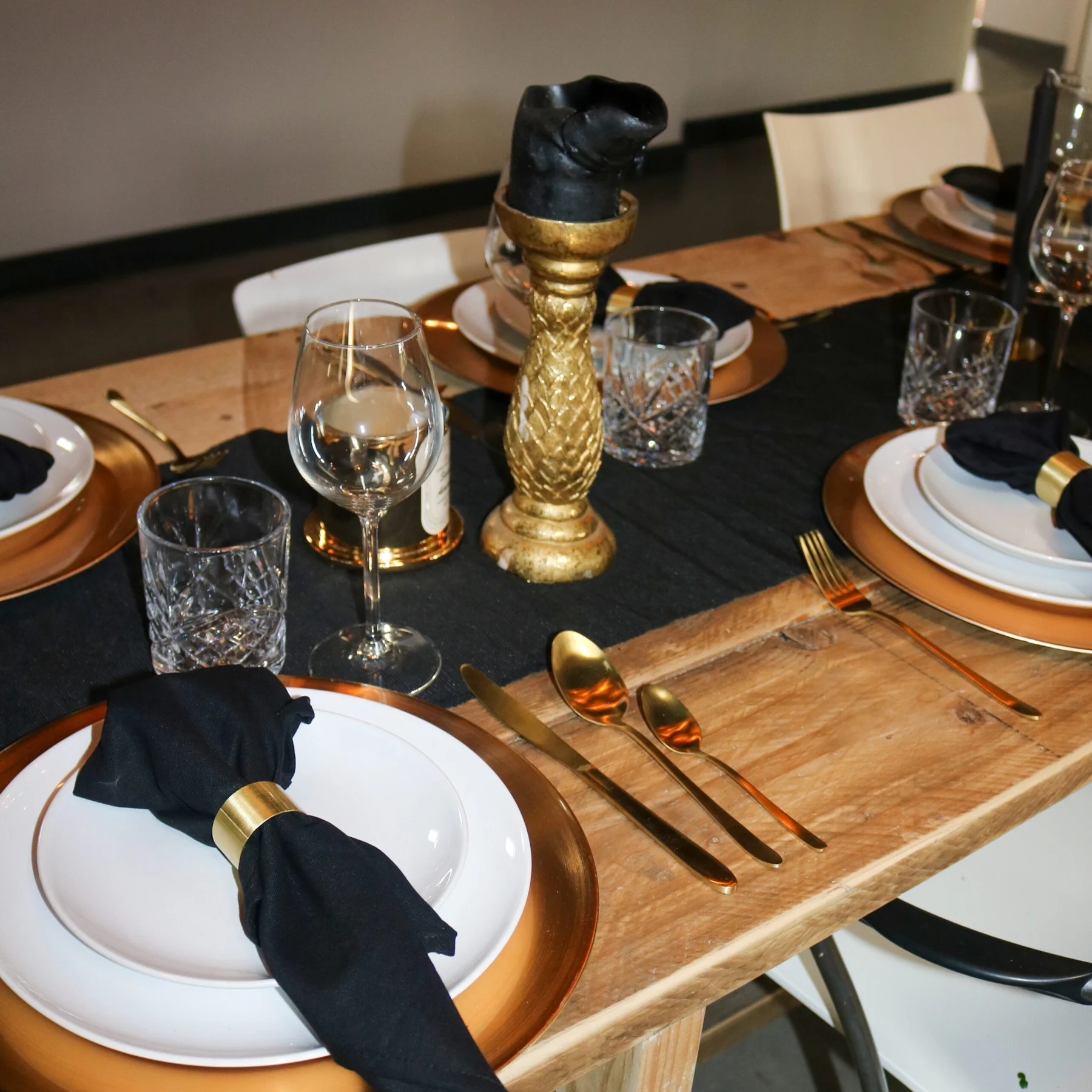 Zwarte servetten en gouden kandelaars op een feestelijke dinertafel