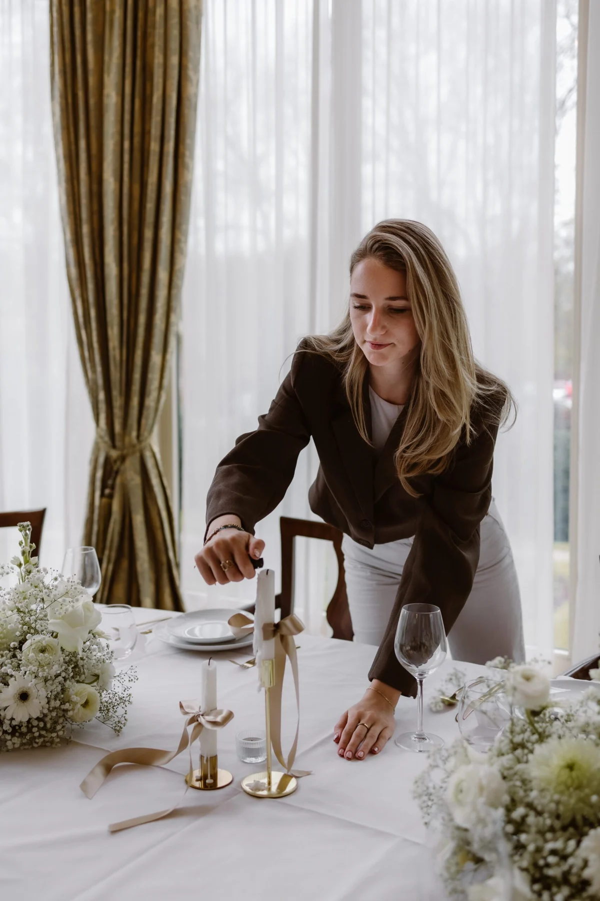 Loes van Leeuwen verzorgt de laatste details van een feestelijk gedekte tafel